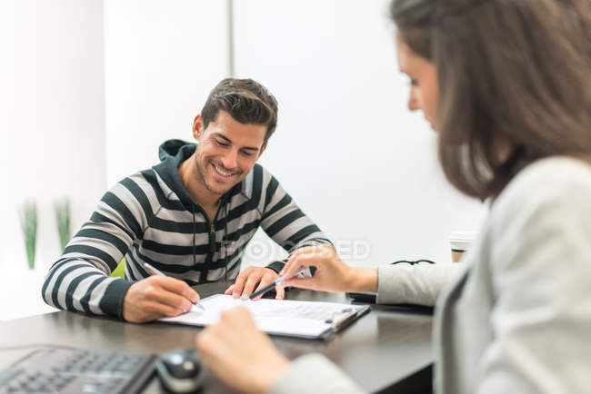 focused_164081552-stock-photo-man-signing-paper-in-office