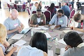 A small group of people gathered around a table working on individual exercises
